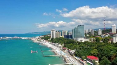 Air Sochi Rusya şehir merkezi gökdeleni tatil beldesi sahil liman dolumu. Karadeniz mavi suyu. Dağ doğal manzarası yaz güneşli gün bulutları
