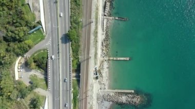 Kıyı şeridi boyunca uzanan bir otoyolun hava aracı görüntüsü. İHA uçuşu kıyı boyunca ve yol boyunca. 