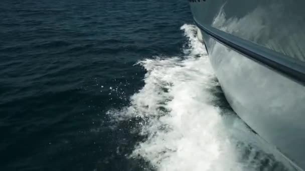 Vista desde la cubierta del yate en la proa, de cerca. Vista lateral con mar verde y olas. Concepto, estilo de vida y libertad. Movimiento lento. — Vídeo de stock