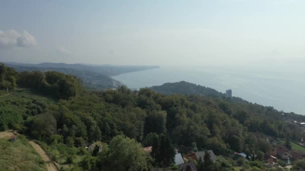 Widok z lotu ptaka na wybrzeże, turkusowe morze, pociąg plażowy i spektakularne góry, Soczi, Rosja. — Wideo stockowe