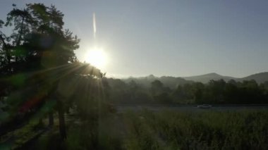 Kırsal kesimde sabahın erken saatlerinde aydınlık bir şafak. Sıcak sabah güneşi altında doğal vahşi doğanın manzarası. Sis içinde gün doğumu şafağın altın ışığı. Doğa. Hava görünümü. 