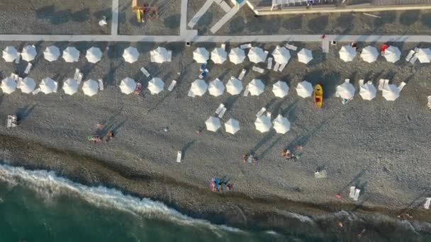 Vista desde arriba, impresionante vista aérea de una playa con sombrillas y un hermoso mar turquesa. — Vídeos de Stock