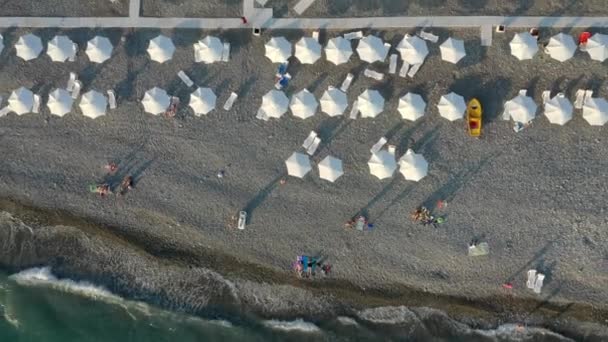 Vista desde arriba, impresionante vista aérea de una playa con sombrillas y un hermoso mar turquesa. — Vídeos de Stock