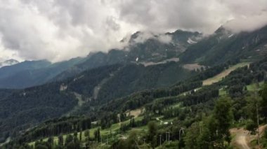 Bulutların arasındaki güzel dağların üzerinde uçan drone.