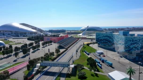 Rusya, Soçi - 01 Nisan 2021: formula _ 1 Sochi, Soçi Olimpiyat köyü. Güneşli yaz gününde, kasabanın yakınında yarış için stadyum inşaatı. Hava görünümü. — Stok video