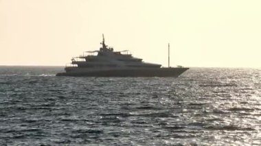 Gün batımında açık denizde yelken açacağız. Yat gün batımında dalgalar üzerinde yelken açar. Sürat teknesi denizde geziyor.