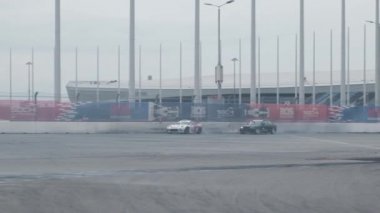 Sochi, RUSSIA - 05 Nisan 2021: Sochi otodrom yarış pistinde sürüklenen iki arabanın yavaş hareketi. Hız. Tüttür. Arena. Asfalt. Bolide. Spor. Yarışçı. Aşırıya kaçmış. Sürüklen. 