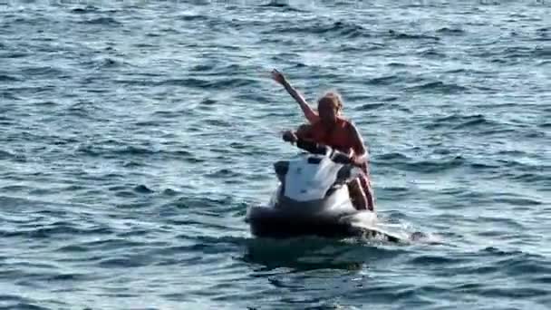 Sochi, Rusland - 10 apr 2021: HAPPY COUPLE på JET SKI. Teenager par krydstogter havet på en jet ski. – Stock-video