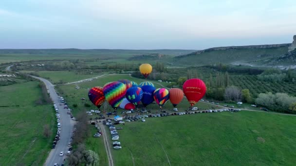 Vista aérea de un lanzamiento matutino de globos de aire caliente en un festival de globos desde el llenado hasta el despegue. — Vídeos de Stock