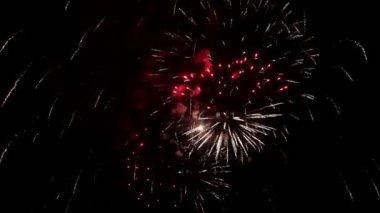 Gece gökyüzünde havai fişek gibi parlayan ışıklar. Parlak havai fişek gösterisi. Yeni yıl arifesi havai fişek kutlaması. Gece gökyüzünde çok renkli havai fişekler. Güzel renkli gece patlamaları Siyah gökyüzünde. 