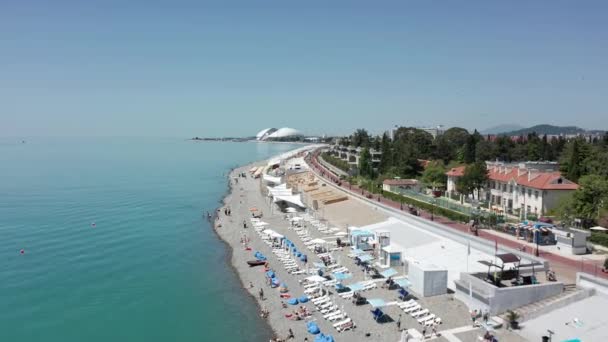 Вид сверху под высоким углом. Сцена пляжного моря и города на побережье в солнечный летний день горы и небо фоне. Сочи, Россия — стоковое видео