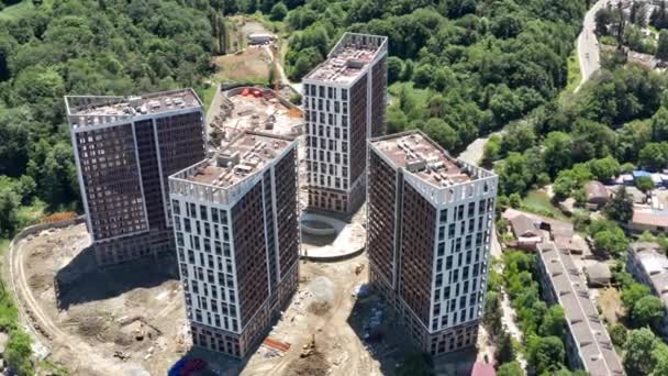 Aereo sopra il cantiere. il lavoro come costruzione, i costruttori lavorano, le case di costruzione. Volo su un sito di sviluppo di nuove costruzioni. Edificio immobiliare. cielo blu chiaro vista aerea — Video Stock