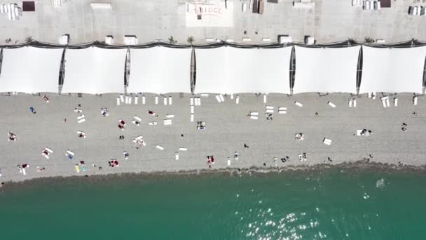 Plage bondé vue de dessus des vacances. S'amuser sur la plage l'été. Vue aérienne. Vue aérienne du haut vers le bas des parasols et des personnes se relaxant à la plage. vacances tropicales amusantes et fond d'été — Video