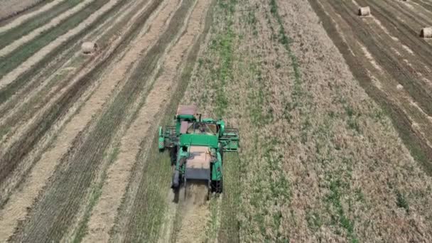 Kombiniert auf dem Feld. Luftaufnahme von Erntemaschinen. Erntezeit. Roggen und Gerste. Autonomer Transport in der Landwirtschaft. Blick von oben auf Erntemaschinen bei der Arbeit im Weizenfeld. — Stockvideo