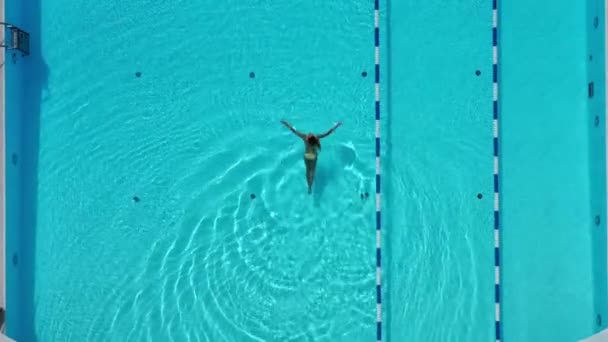 若い女性は夏にプールの冷たい水で楽しんでいます 水泳の女性の上からの空中ビュー 最上階だ 水着の女の子は ホテルのプールでリラックスを楽しんでいます 休暇や贅沢なスパ レストのコンセプト — ストック動画