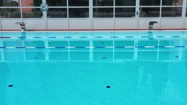 Piscina all'aperto con ripple blu acqua turchese e ringhiere in acciaio scale. Scaletta corrimano inox per discesa in piscina. Vista aerea della piscina pubblica — Video Stock