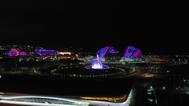 Soči Olympic Park, letecký výhled, olympijský oheň a taneční fontána v noci shora. Soči, Rusko - 10. června 2021 — Stock video