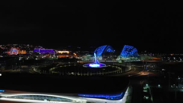 Ολυμπιακό Πάρκο Σότσι, εναέρια θέα, Ολυμπιακή φλόγα και βρύση χορού τη νύχτα από ψηλά. Sochi, Ρωσία - 10 Ιουνίου 2021 — Αρχείο Βίντεο