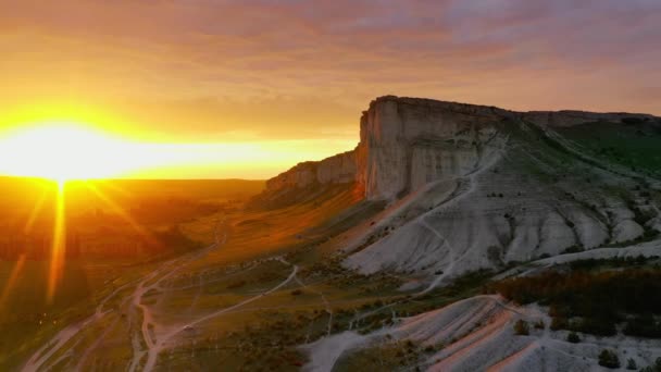 Natuurlandschap van Ak-Kaya White Rock bij zonsondergang. De Krim. Opnamen vanuit de lucht. Prachtig landschap bij zonsondergang. Hoge bergen. Openluchtrecreatie. Bovenaanzicht. Natuurreservaat. Een historische plaats. — Stockvideo