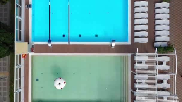 Utomhus pool med krusning blå turkos vatten och Stål räcken trappor. Stege rostfritt ledstänger för nedstigning i poolen. Flygfoto över den offentliga poolen — Stockvideo