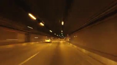 Tünelde araba kullanırken arabanın camından zaman geçiyor. Birinci şahıs görünümü.