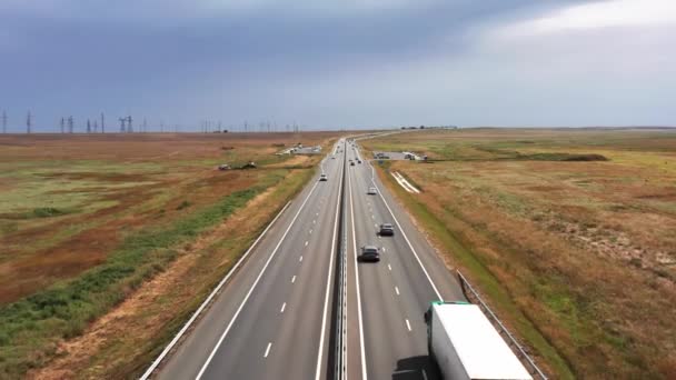 Coches y camiones viajan por la autopista. Vista superior. Grabación de video aéreo. Clima nublado. Una autopista moderna. — Vídeo de stock