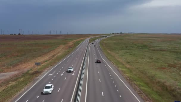Coches y camiones viajan por la autopista. Vista superior. Grabación de video aéreo. Clima nublado. Una autopista moderna. — Vídeo de stock