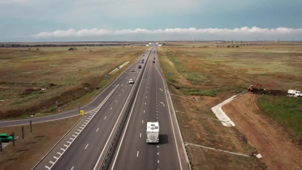 Coches y camiones viajan por la autopista. Vista superior. Grabación de video aéreo. Clima nublado. Una autopista moderna. — Vídeo de stock