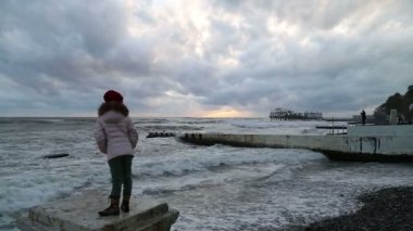 İskele ve fırtına izlerken sert hava, küçük kız olduğunu