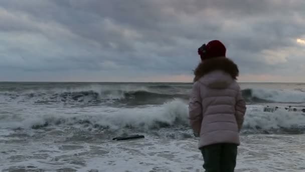 Meisje in slechte weersomstandigheden is op de pier en het kijken naar de storm — Stockvideo