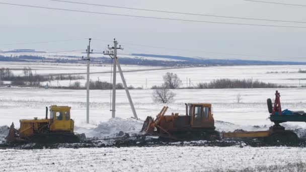 Tractors transport drilling equipment through mud — Stock Video