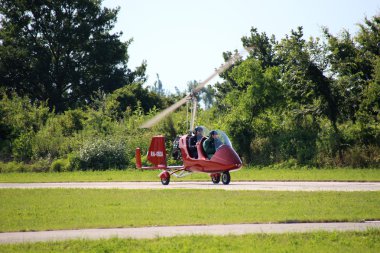 Red gyroplane taking off clipart