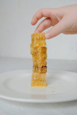 Beyaz tabakta ballı bal peteği parçaları var. Nand ile yakın plan. Dikey fotoğraf