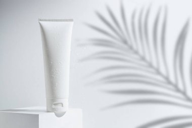 Palmiye yaprağı Hindistan cevizi ağacı arka planında cilt bakım konseptiyle güzellik modası makyaj şişesi losyonu ürünü.