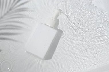 Su havuzu arka planında cilt sağlığı konsepti olan güzellik modası makyaj şişesi losyonu ürünü.