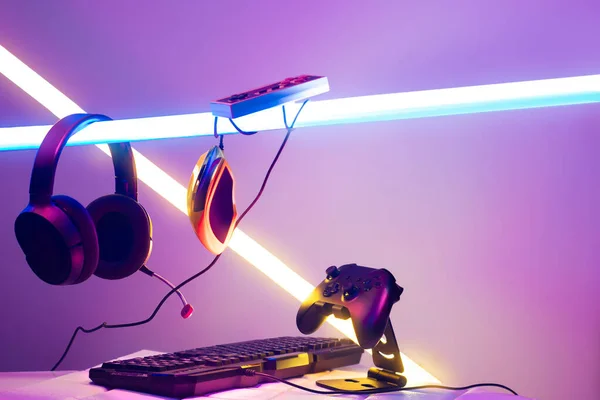 游戏玩家装置 通过控制杆与电脑耳机和鼠标在霓虹灯发光 游戏和出口的挑战 流线型在线游戏 比赛的概念 — 图库照片