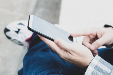 online ağ teknolojisi için akıllı telefon kullanan genç çocuk; kamu parkında cep telefonu kullanan adam