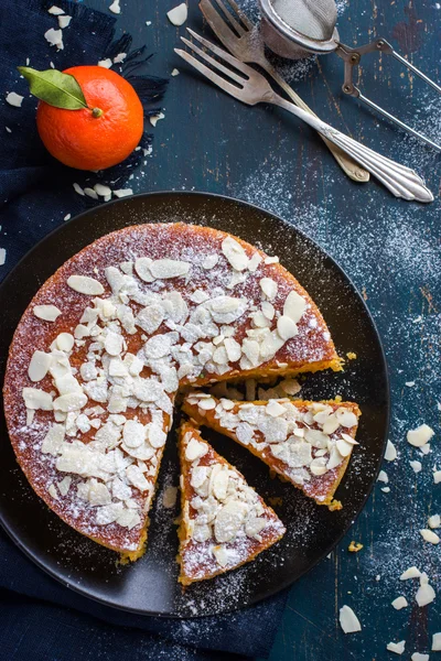 Tangerine and almond cake on dark blue background, — Stock Photo, Image