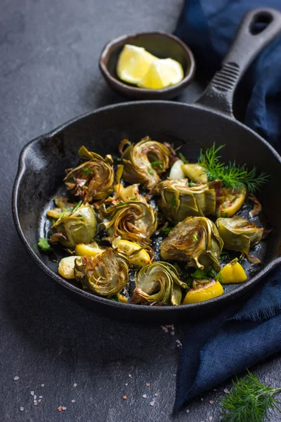 Fried artichokes with garlic and lemon on pan — Stock Photo, Image