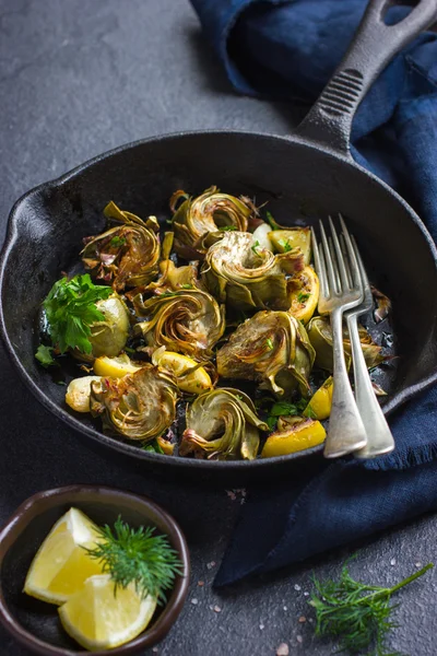 Fried artichokes with garlic and lemon on pan — Stock Photo, Image