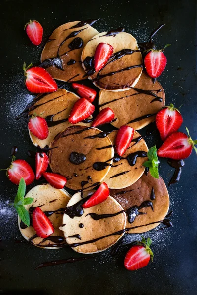 Frittelle con fragola fresca e salsa di cioccolato sul dorso nero — Foto Stock