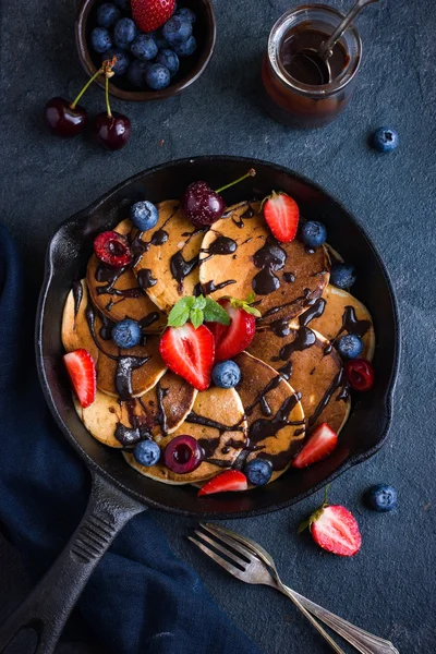 Pfannkuchen mit frischen Beeren und Schokoladensauce auf Pfanne, schwarzer Ba — Stockfoto