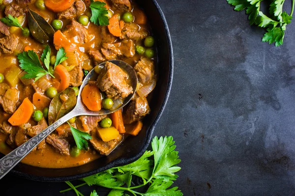 Beef stew with vegetables on dark background — Stock Photo, Image