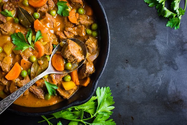 Estofado de ternera con verduras sobre fondo oscuro —  Fotos de Stock