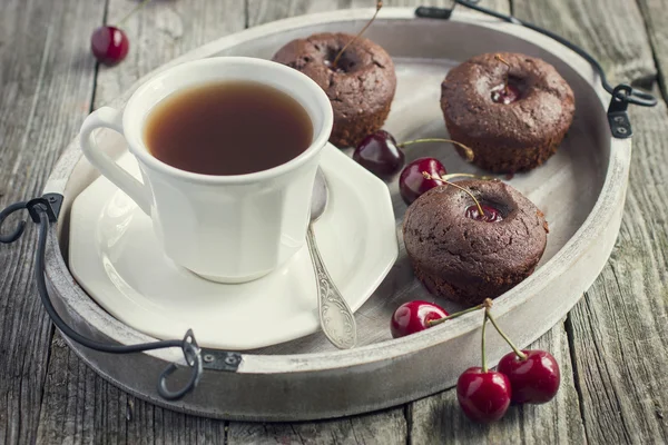 Κεράσι muffins και φλιτζάνι τσάι σε ένα ξύλινο δίσκο — Φωτογραφία Αρχείου