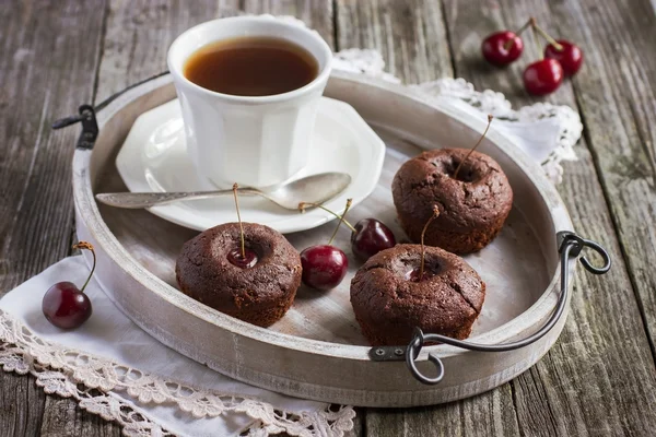 Cseresznyés muffin és a csésze tea egy fa tálcán — Stock Fotó