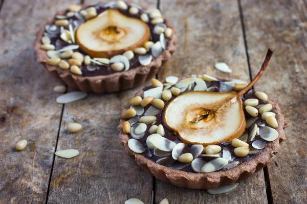 Chocolate tartlets with pear and nuts — Stock Photo, Image