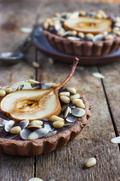 Chocolate tartlets with pear and nuts — Stock Photo, Image