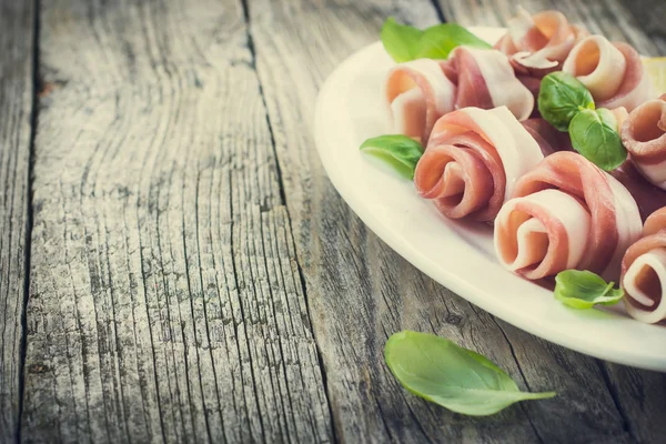 Prosciutto con albahaca en un plato blanco —  Fotos de Stock