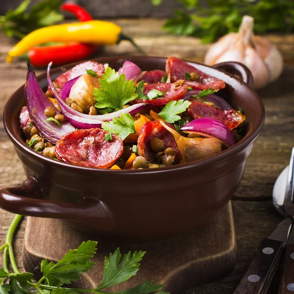 Чечевица с колбасой и овощами — стоковое фото